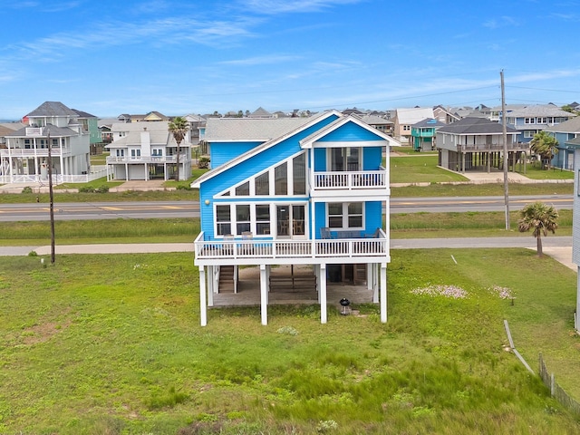 22915 Gulf Dr, Galveston, TX 77554 - rear view of property with a balcony, a yard, and a residential view