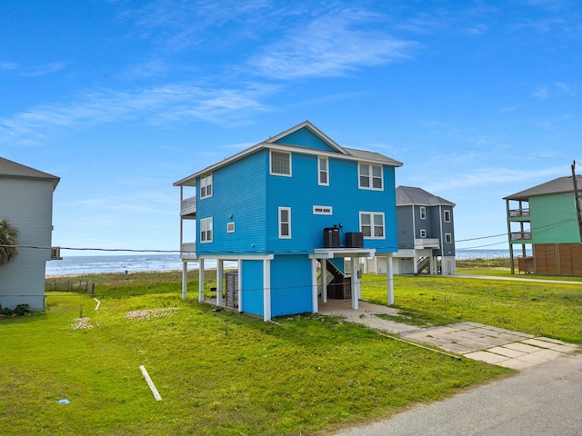 22915 Gulf Dr, Galveston, TX 77554 - back of house featuring a carport, a water view, and a yard