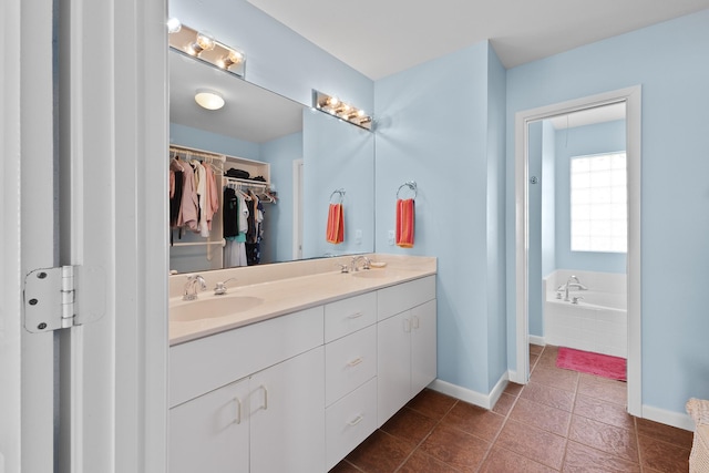 22915 Gulf Dr, Galveston, TX 77554 - bathroom with double vanity, a walk in closet, baseboards, and a sink