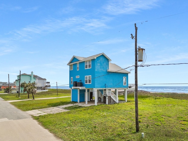 22915 Gulf Dr, Galveston, TX 77554 - exterior space with a lawn, a water view, stairway, and a carport
