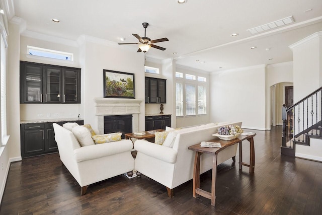 13217 Green Hills Dr, Houston, TX 77077 - living room featuring a glass covered fireplace, arched walkways, ornamental molding, a ceiling fan, and recessed lighting