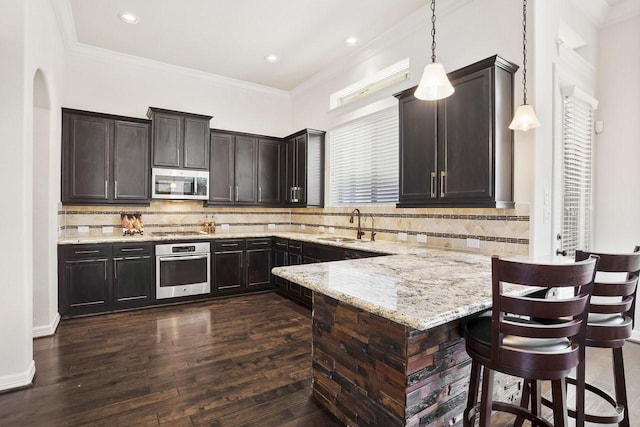 13217 Green Hills Dr, Houston, TX 77077 - kitchen featuring appliances with stainless steel finishes, a sink, a peninsula, light stone counters, and a kitchen breakfast bar