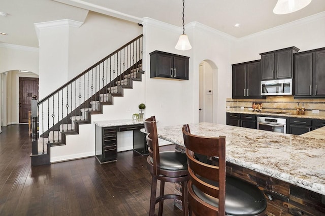 13217 Green Hills Dr, Houston, TX 77077 - kitchen featuring stainless steel appliances, arched walkways, light stone counters, crown molding, and recessed lighting