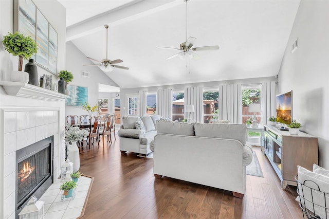 19122 Dee Woods Dr, Humble, TX 77346 - living room with high vaulted ceiling, a ceiling fan, a tile fireplace, wood finished floors, and beamed ceiling