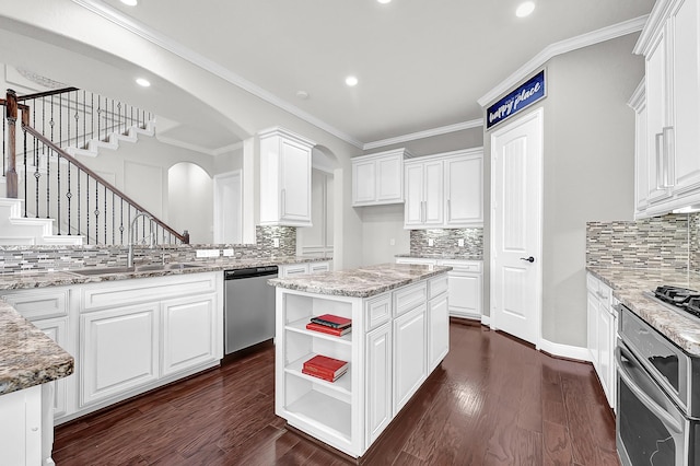3411 Heather Garden Trl, Richmond, TX 77406 - kitchen with appliances with stainless steel finishes, tasteful backsplash, a sink, arched walkways, and recessed lighting