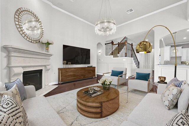 3411 Heather Garden Trl, Richmond, TX 77406 - living area featuring arched walkways, a chandelier, stairway, ornamental molding, and wood finished floors