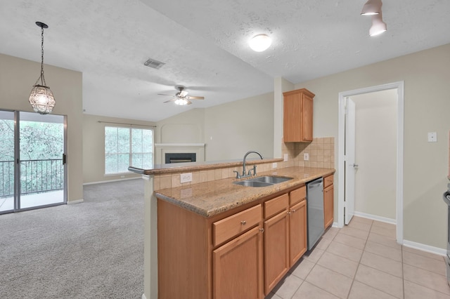 kitchen featuring decorative backsplash, dishwasher, a fireplace, a ceiling fan, and a sink