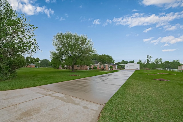 exterior space featuring a yard, a garage, driveway, and an outdoor structure