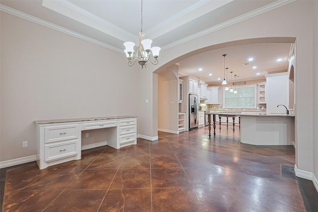 interior space with a tray ceiling, arched walkways, baseboards, and recessed lighting