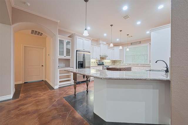 kitchen featuring crown molding, arched walkways, visible vents, a sink, and stainless steel appliances