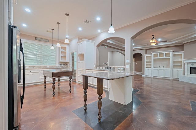 kitchen with stainless steel fridge with ice dispenser, visible vents, ceiling fan, white cabinetry, and a breakfast bar area