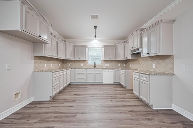 kitchen featuring under cabinet range hood, light wood-style floors, visible vents, dishwasher, and a sink