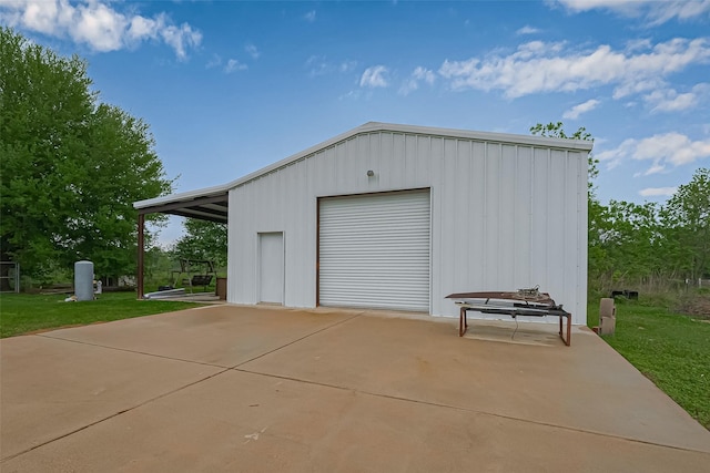 view of outbuilding featuring concrete driveway and an outdoor structure