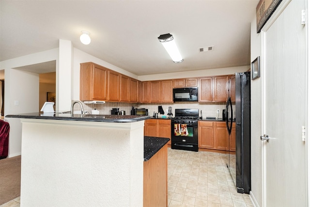 22110 Orchard Dale Dr, Spring, TX 77389 - kitchen with tasteful backsplash, visible vents, a sink, a peninsula, and black appliances