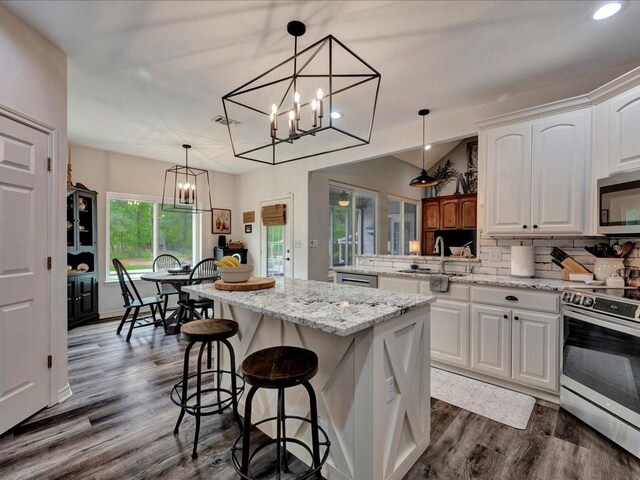 3065 S Fm 1194, Lufkin, TX 75904 - kitchen with a chandelier, tasteful backsplash, a center island, stainless steel appliances, and white cabinets