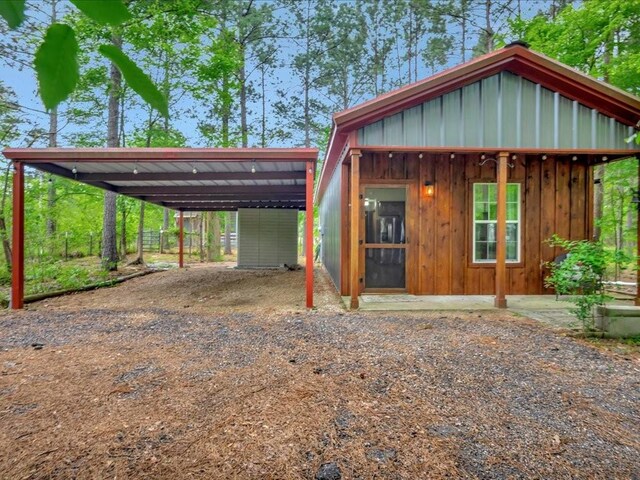 3065 S Fm 1194, Lufkin, TX 75904 - view of front of house featuring board and batten siding, an outbuilding, driveway, and a detached carport