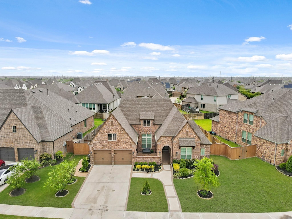 french country inspired facade with a garage, brick siding, a residential view, driveway, and a shingled roof