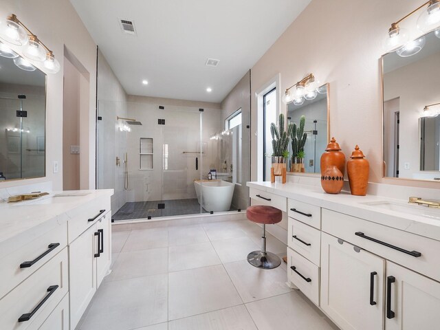 full bathroom with a shower stall, two vanities, tile patterned flooring, a freestanding bath, and recessed lighting