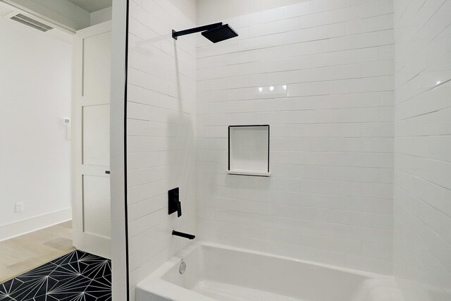 bathroom featuring bathing tub / shower combination and baseboards