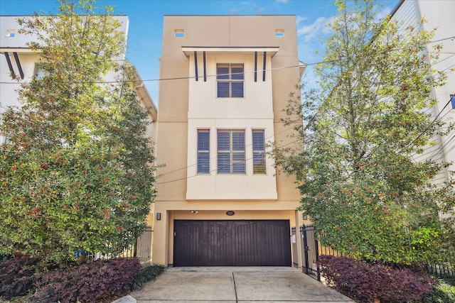 view of front facade with a garage, stucco siding, and driveway