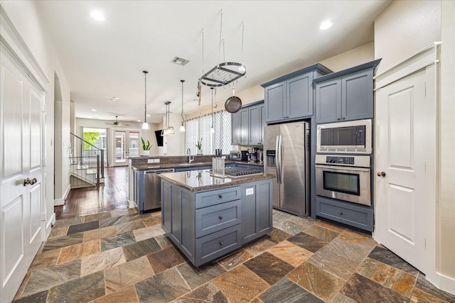 kitchen featuring a peninsula, recessed lighting, appliances with stainless steel finishes, and stone tile floors