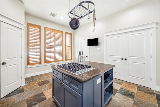 kitchen featuring stainless steel gas stovetop, stone tile flooring, visible vents, open shelves, and blue cabinetry