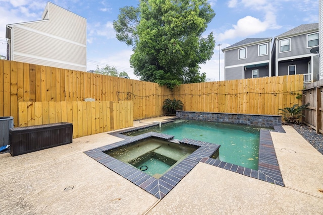 view of swimming pool featuring a pool with connected hot tub and a fenced backyard
