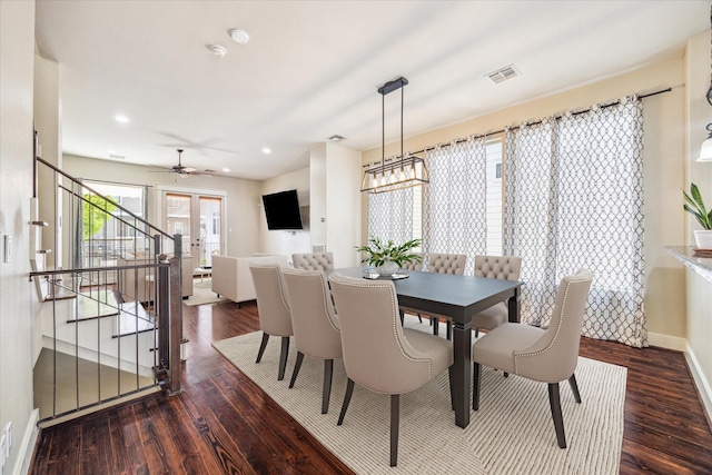 dining space featuring baseboards, stairs, visible vents, and wood finished floors