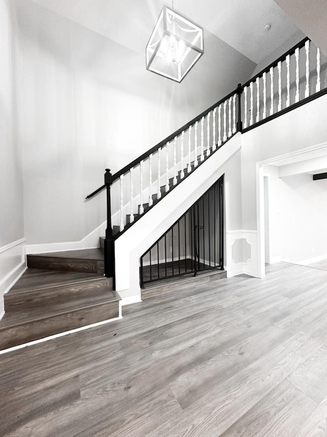 537 Natchez Park, Conroe, TX 77302 - stairway with wood finished floors, a towering ceiling, baseboards, and wainscoting
