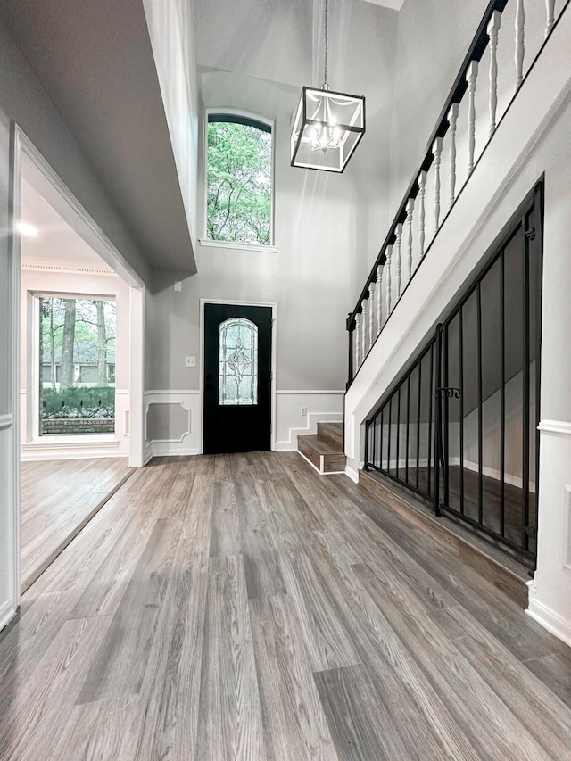 537 Natchez Park, Conroe, TX 77302 - foyer with a chandelier, stairs, wood finished floors, a decorative wall, and wainscoting