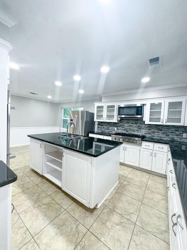 537 Natchez Park, Conroe, TX 77302 - kitchen with appliances with stainless steel finishes, decorative backsplash, dark countertops, and a center island with sink