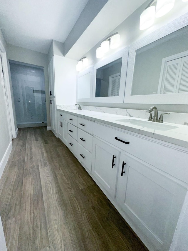 537 Natchez Park, Conroe, TX 77302 - bathroom featuring wood finished floors, a shower stall, double vanity, and baseboards