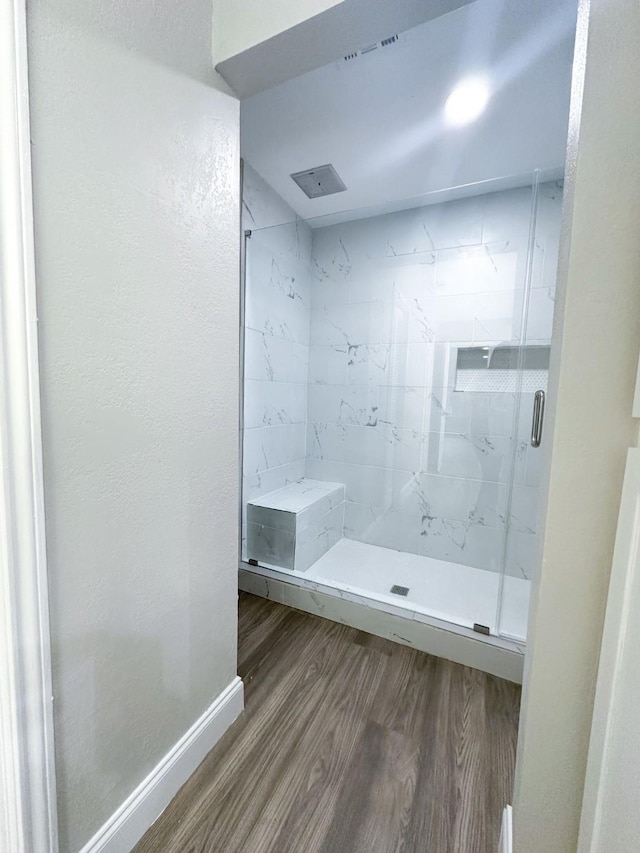 537 Natchez Park, Conroe, TX 77302 - bathroom with wood finished floors, a marble finish shower, baseboards, and a textured wall