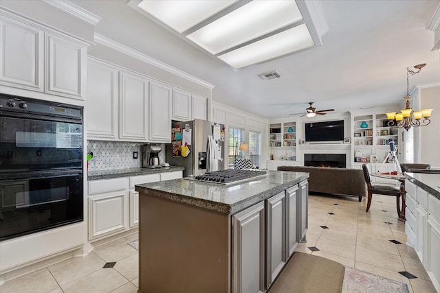 5206 Summer Snow Dr, Houston, TX 77041 - kitchen with stainless steel appliances, light tile patterned floors, a ceiling fan, a tiled fireplace, and ornamental molding