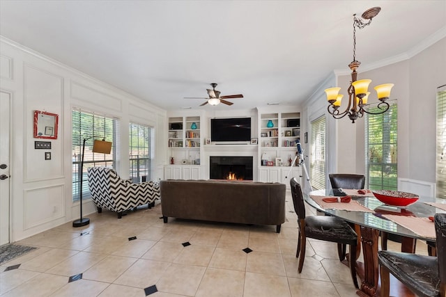 5206 Summer Snow Dr, Houston, TX 77041 - living room featuring ornamental molding, light tile patterned flooring, built in shelves, a chandelier, and a lit fireplace