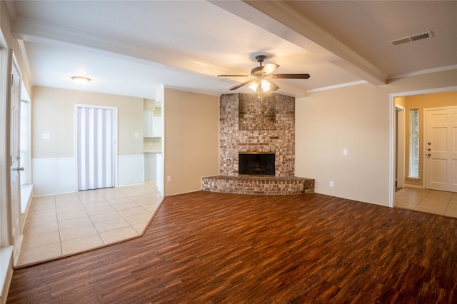 1910 Cobble Creek Dr, Houston, TX 77073 - unfurnished living room with ornamental molding, visible vents, a ceiling fan, a fireplace, and wood finished floors