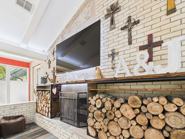 1310 Golden Bear Ln, Kingwood, TX 77339 - detailed view of wood finished floors, beamed ceiling, a fireplace, and brick wall