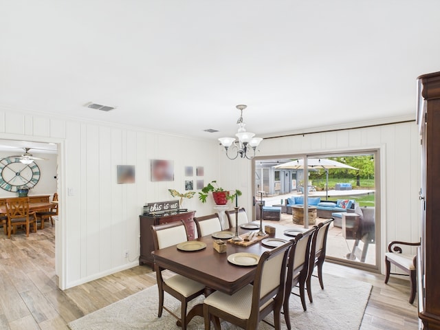 1310 Golden Bear Ln, Kingwood, TX 77339 - dining area with light wood-type flooring, a chandelier, crown molding, a decorative wall, and ceiling fan