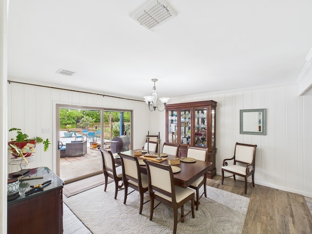 1310 Golden Bear Ln, Kingwood, TX 77339 - dining area featuring a chandelier, light wood-style floors, crown molding, and baseboards