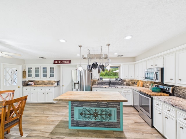 1310 Golden Bear Ln, Kingwood, TX 77339 - kitchen featuring appliances with stainless steel finishes, tasteful backsplash, a sink, white cabinets, and recessed lighting