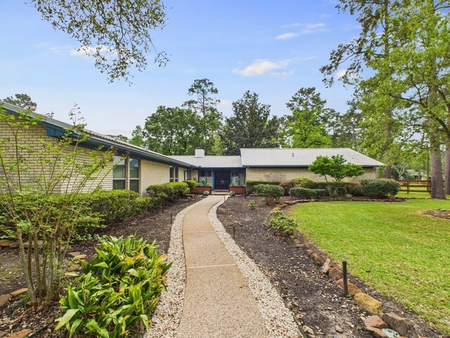 1310 Golden Bear Ln, Kingwood, TX 77339 - view of front facade with brick siding, a front yard, and a chimney