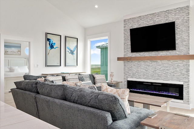 986 Bolivar Dunes Blvd, Gilchrist, TX 77617 - living room with a glass covered fireplace, wood finished floors, lofted ceiling, and recessed lighting
