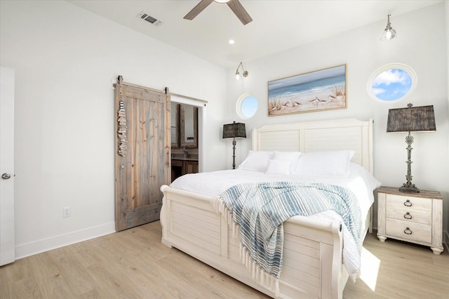 986 Bolivar Dunes Blvd, Gilchrist, TX 77617 - bedroom with a barn door, wood finished floors, a ceiling fan, connected bathroom, and recessed lighting