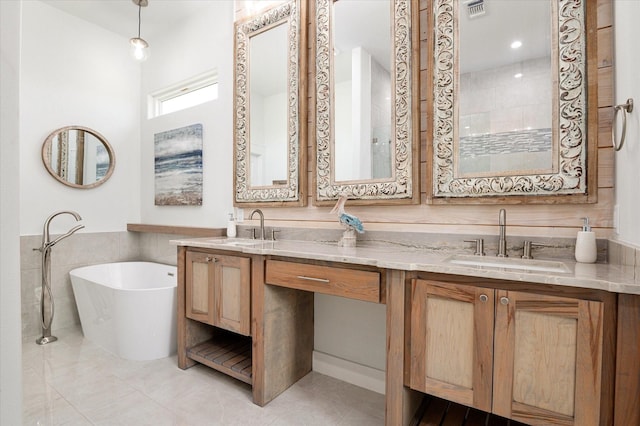 986 Bolivar Dunes Blvd, Gilchrist, TX 77617 - full bath with a freestanding tub, double vanity, tile patterned floors, and tile walls