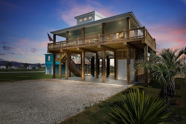 986 Bolivar Dunes Blvd, Gilchrist, TX 77617 - coastal home featuring a carport, gravel driveway, stairway, a metal roof, and a wooden deck