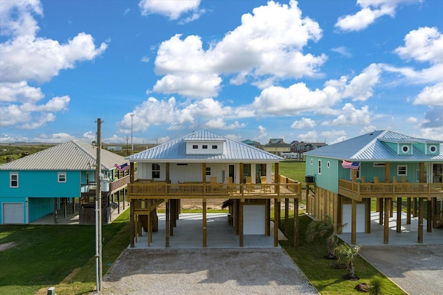 986 Bolivar Dunes Blvd, Gilchrist, TX 77617 - raised beach house featuring a carport, gravel driveway, a front yard, a metal roof, and stairs