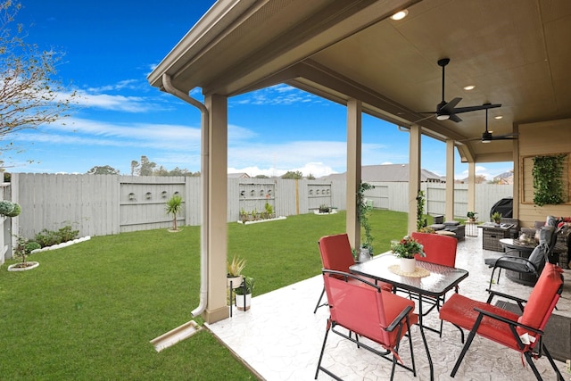 view of patio with outdoor dining area, a fenced backyard, and a ceiling fan