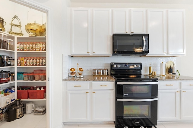 kitchen with white cabinets, black appliances, light stone countertops, and tasteful backsplash