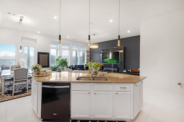kitchen featuring open floor plan, a center island with sink, a sink, dishwasher, and light stone countertops