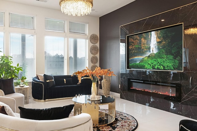 living area with a high end fireplace, a chandelier, and visible vents